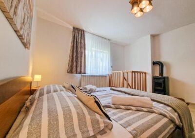 Double bedroom beside the wooden stair railing