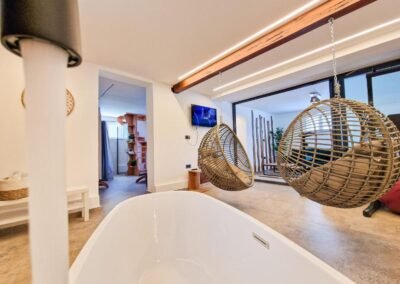 Freestanding bath and hanging chairs in the wellness room