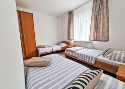 Three single beds beside a bedroom window