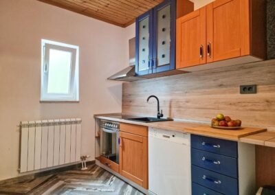 Kitchen with blue and wooden cabinets at Grga's Villa