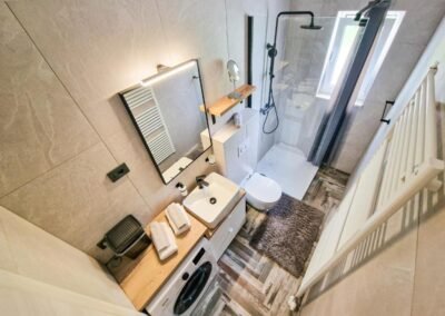 Bathroom with shower, sink and washing machine